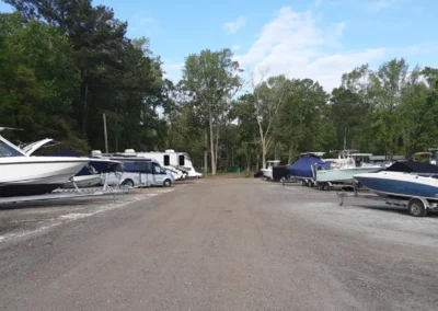 Boats of different sizes are parked in a lot at Matthews Boat and RV Storage, organized neatly for storage.